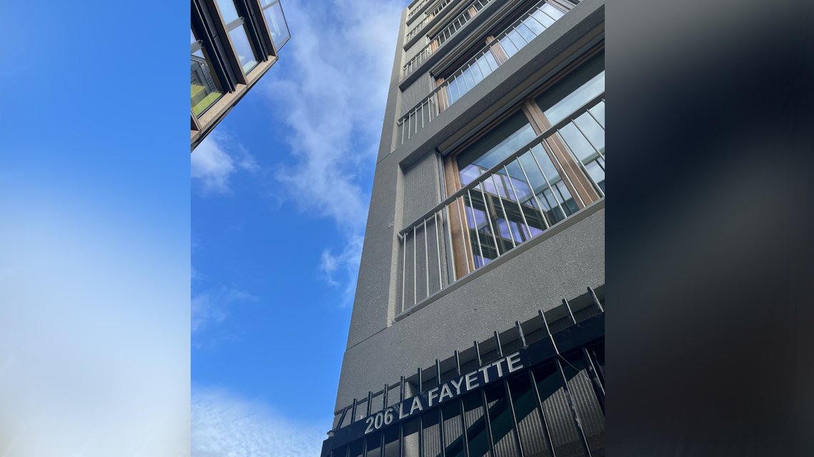 Rede em espiral de aço inoxidável na parte da frente de uma escada exterior. A malha metálica foi feita por medida para revestir as escadas deste edifício 206 Lafayette HQ. Projetado por Think Tank Architecture.  - <p>Para o projeto QG 206 Lafayette, a rede em espiral de aço inoxidável Torroja F foi selecionada pela Think Tank Architecture e fabricada à medida para ser utilizada como revestimento de escadas exteriores e como enchimento de vedações com uma estrutura metálica branca assente num deck de madeira exterior. Para mais informações, contacte-nos <a href=