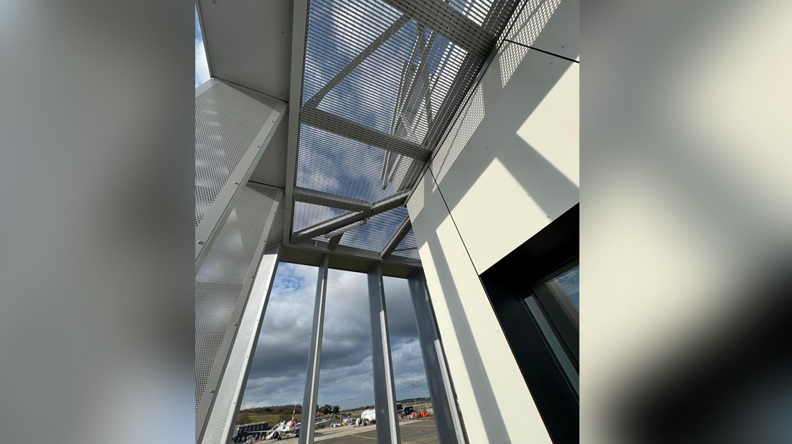 Revestimento metálico em circulação exterior - <p>Execução de passarela metálica com proteção solar em grade eletrossoldada Slot sob medida.</p>