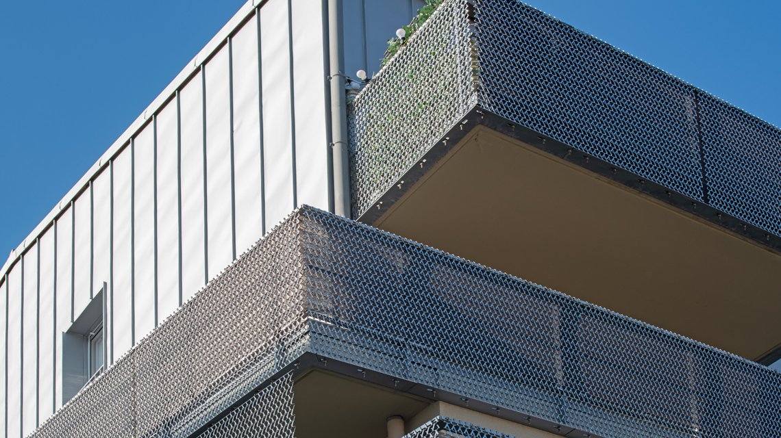 Fachada e gradeamentos em malha espiral de aço inoxidável www.maillemetaldesign.pt - <p>Neste projeto de desenvolvimento habitacional em Malakoff, a rede metálica de aço inoxidável foi utilizada como enchimento para grades e revestimento das fachadas dos edifícios. A rede em espiral de aço inoxidável EIFFEL40100 e o seu sistema de fixação TF60. A malha permite o preenchimento de gradeamentos e o revestimento arquitetónico contínuo, criando uma leitura fluida e rítmica da envolvente do edifício.</p>