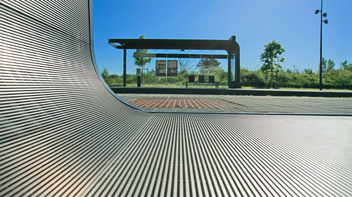 Caillebotis curvado em slot inox 316L – Continuidade arquitetónica - <p>Caillebotis metálico em grelha eletrossoldada slot inox 316L, curvado à medida para garantir continuidade estética entre revestimento vertical e pavimento técnico. Solução robusta para infraestruturas públicas e transporte urbano.</p>