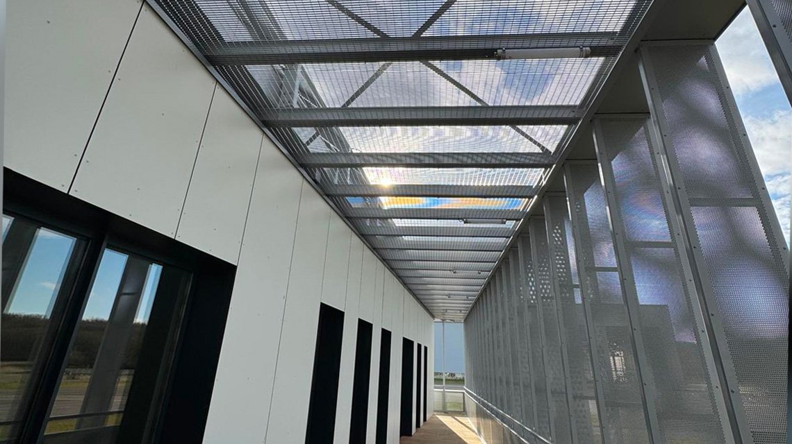 Brise-soleil metálico em passarela - <p>Detalhe técnico da aplicação da grade eletrossoldada Slot como proteção solar em passarela R+1.</p>